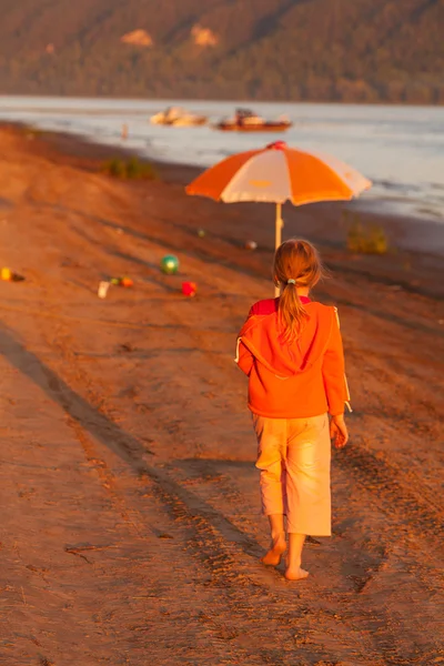 Little girl running along the beach in the sunshine — Stock Photo, Image