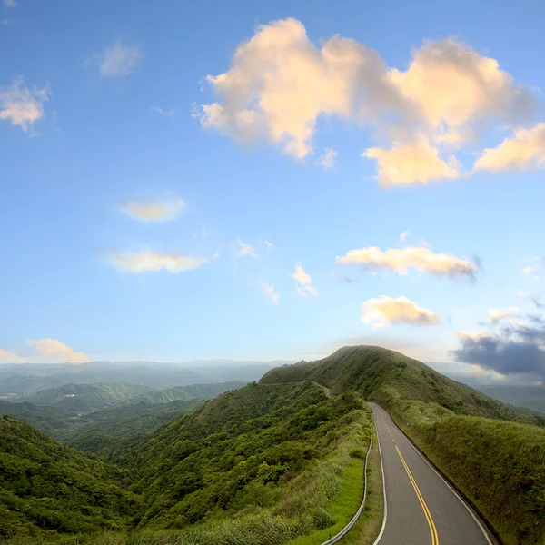 Estrada verde com céu azul — Fotografia de Stock