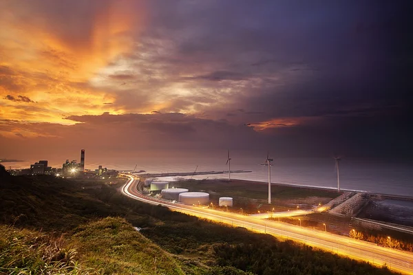 Uma estrada e moinhos de vento durante o pôr do sol , — Fotografia de Stock