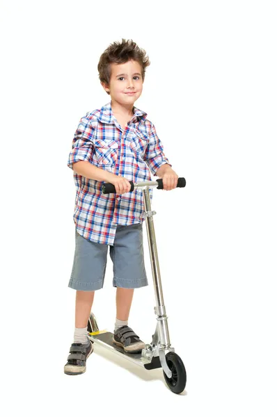Niño peludo travieso en pantalones cortos y camisa con scooter Imagen De Stock