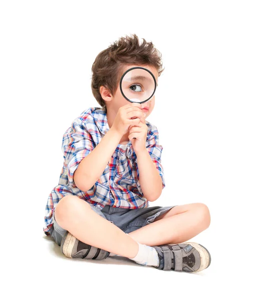 Attentive little boy with weird hair researching using magnifier — Stock Photo, Image