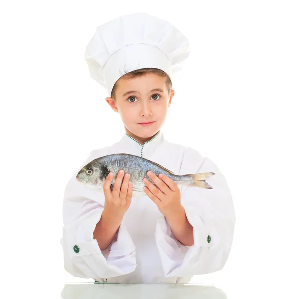 Liten pojke kock i uniform presentera dorado fisk — Stockfoto