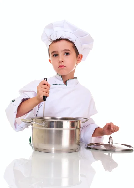 Kleine jongen chef-kok in uniform met pollepel stiring in de pot — Stockfoto