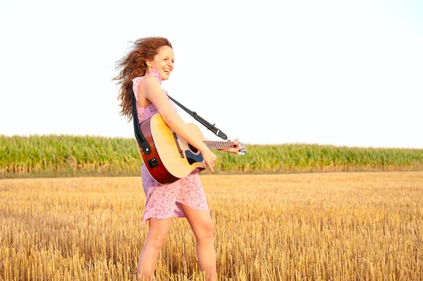 Redhead woman playing guitar outdoors — Stock Photo, Image