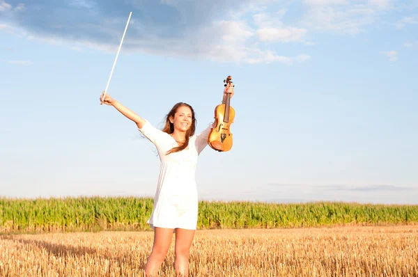 Young woman holding violin and bow outdoors — Stock Photo, Image