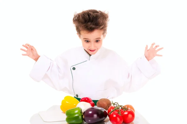 Šéfkuchař malý chlapec v uniformě vaření vegatables — Stock fotografie