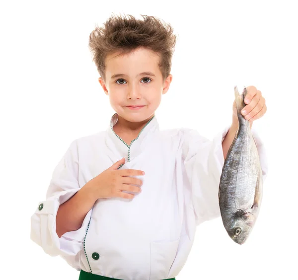 Pequeno menino chef em uniforme apresentando peixe dorado — Fotografia de Stock