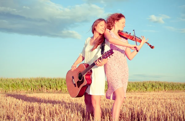 Dwóch młodych kobiet gra gitara i skrzypce na zewnątrz. Podziel tonowanie — Zdjęcie stockowe