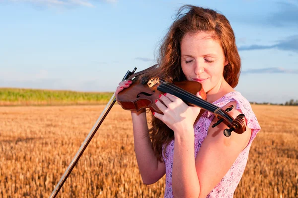 Влюблена в музыку. Женщина целует скрипку — стоковое фото