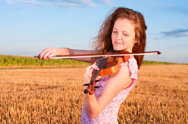 Rothaarige Frau spielt Geige im Freien auf dem Feld — Stockfoto