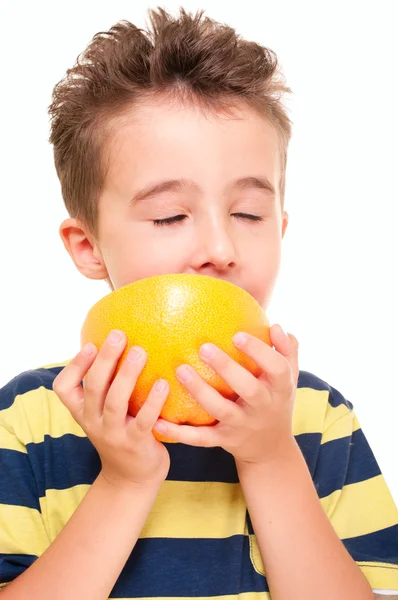 Маленький мальчик eatich грейпфрут с удовольствием — стоковое фото