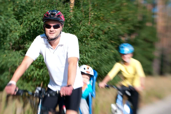 Familia en bicicleta en el bosque soleado — Foto de Stock