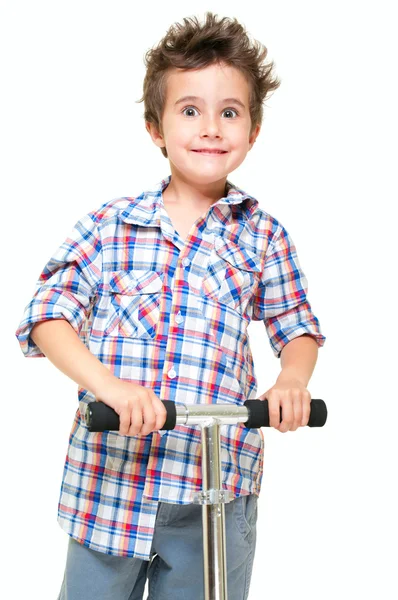 Zlobivý vlasatý chlapeček v krátkých kalhotách a košili s koloběžkou — Stock fotografie