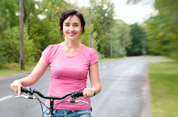 Женщина с велосипедом на лесной дороге. Эффект Ленсбэби — стоковое фото