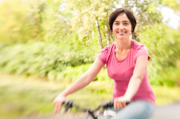Vrouw rijden fiets op bos weide. Lensbaby effect — Stockfoto