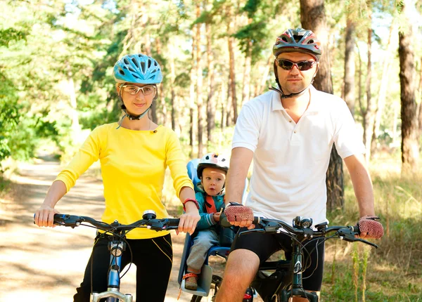 Family on the bike in the sunny forest — Stock Photo, Image