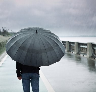 yağmur ve şemsiye ile yalnız bir adam