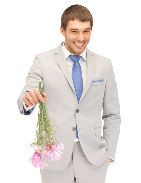 Bonito homem com flores na mão — Fotografia de Stock