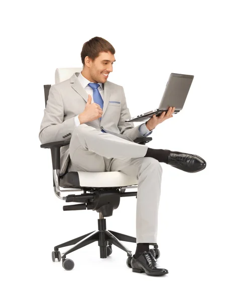 Молодой бизнесмен сидит в кресле с ноутбуком — стоковое фото