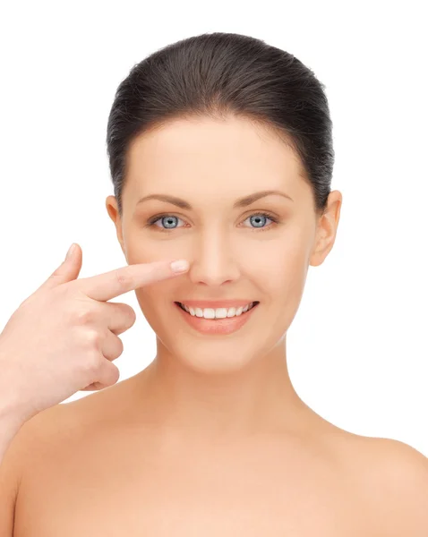 Beautiful woman pointing to nose — Stock Photo, Image