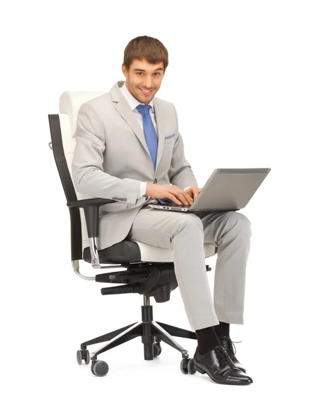 Молодой бизнесмен сидит в кресле с ноутбуком — стоковое фото