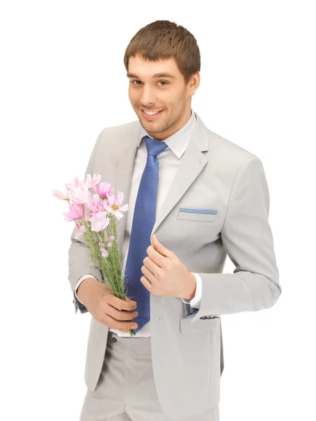 Beau homme avec des fleurs à la main — Photo