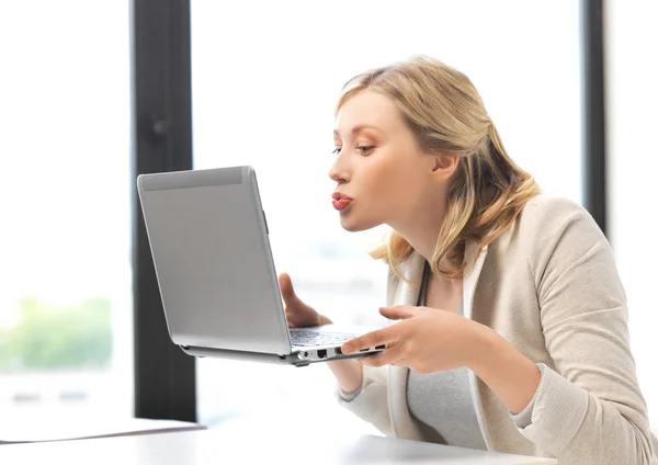Женщина с компьютером целует экран — стоковое фото