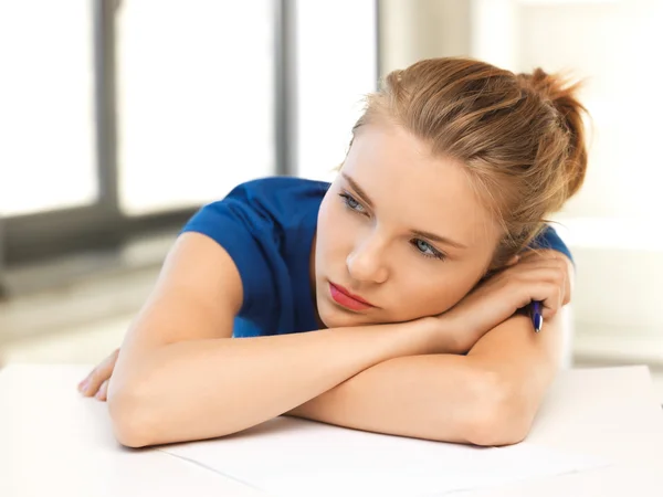 Tired teenage girl with pen and paper — Stock Photo, Image