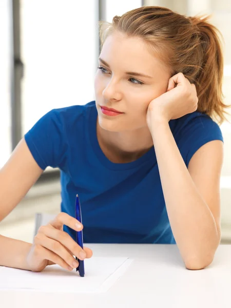 Menina adolescente pensativo com caneta e papel — Fotografia de Stock