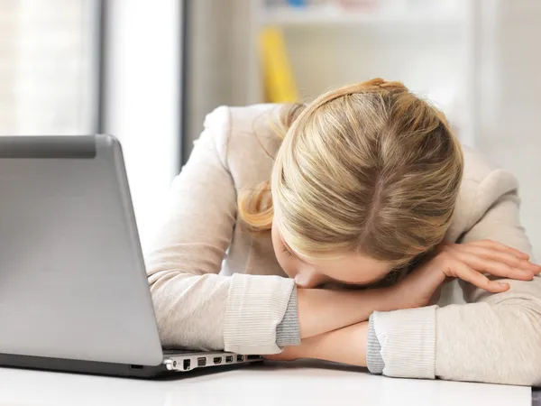 Mujer cansada con ordenador portátil —  Fotos de Stock