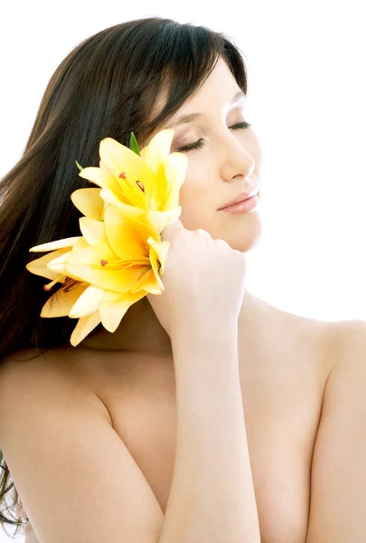 Brünette mit gelben Lilienblüten im Wellnessbereich — Stockfoto
