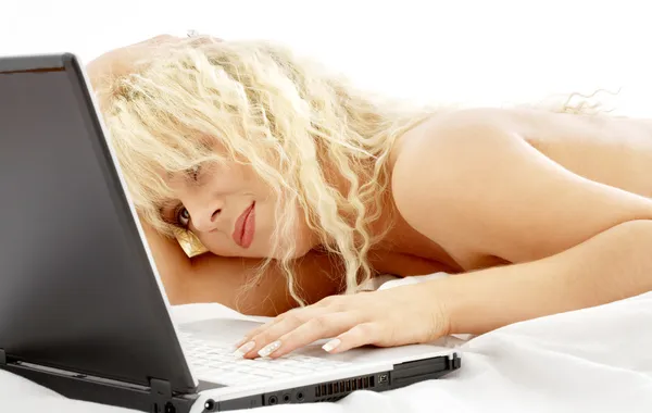Retrato de loiro deitado na cama com laptop — Fotografia de Stock