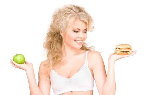 Mujer eligiendo entre hamburguesa y manzana —  Fotos de Stock