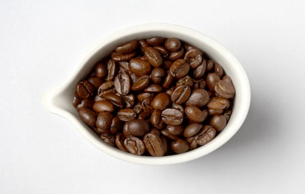Pohár plný kolumbijská kávová zrna — Stock fotografie