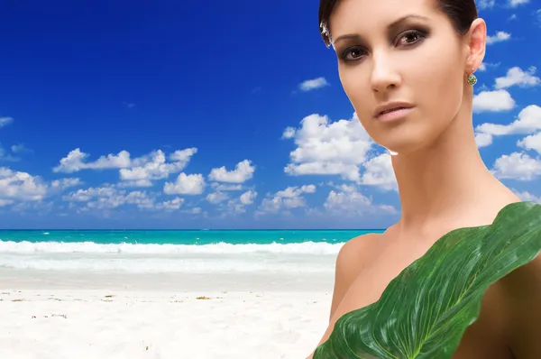 Frau mit grünem Blatt am tropischen Strand — Stockfoto