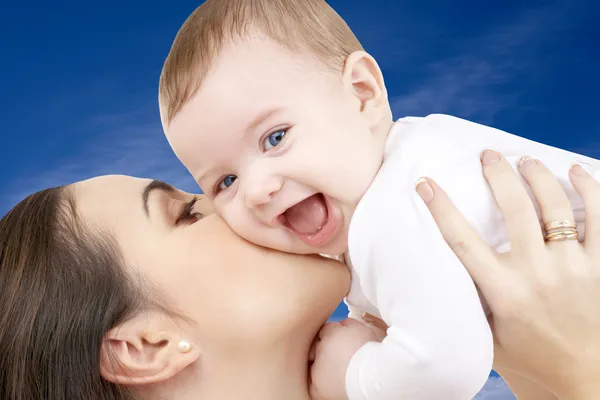 Happy mother with baby boy over blue sky — Stock Photo, Image