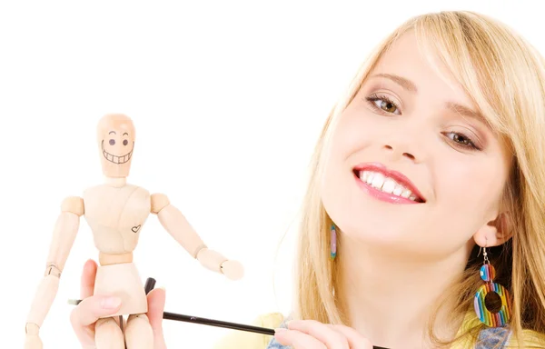 Happy teenage girl with wooden model dummy — Stock Photo, Image