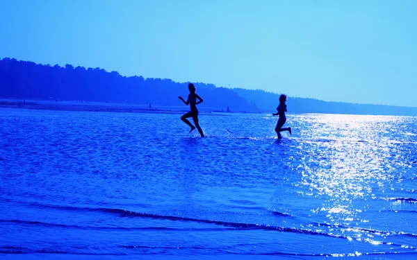Running girls over blue — Stock Photo, Image
