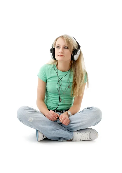Chica adolescente en auriculares sentados en el suelo —  Fotos de Stock