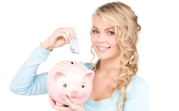 Mooie vrouw met piggy bank en geld Stockfoto