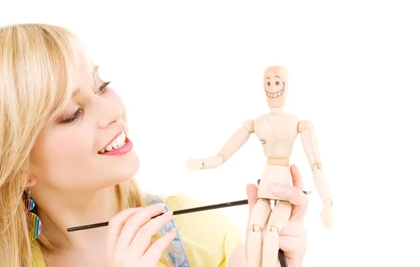 Happy teenage girl with wooden model dummy Stock Photo