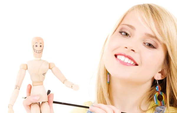 Happy teenage girl with wooden model dummy Stock Image