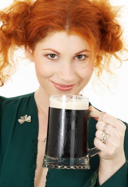 Redhead in green dress with a mug of irish stout beer clipart