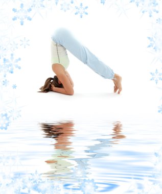 Salamba sirsasana supported headstand on white sand clipart