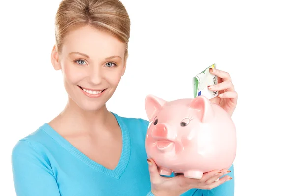 Mooie vrouw met piggy bank en geld — Stockfoto