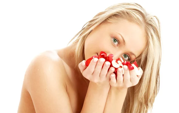 Schöne Blondine im Wellnessbereich mit roten und weißen Rosenblättern — Stockfoto