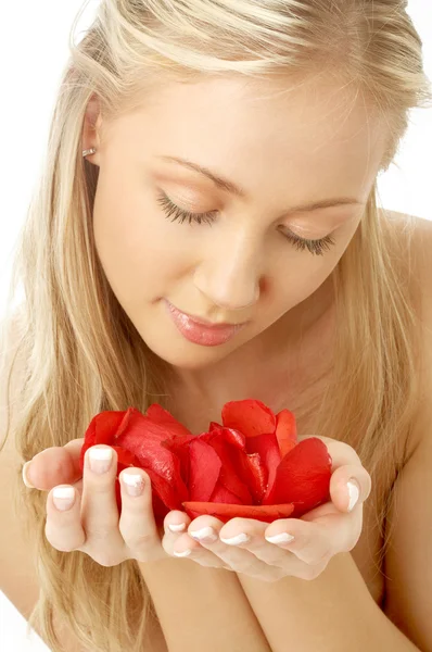 可爱的金发女郎中带有红色的玫瑰花瓣水疗中心 — 图库照片