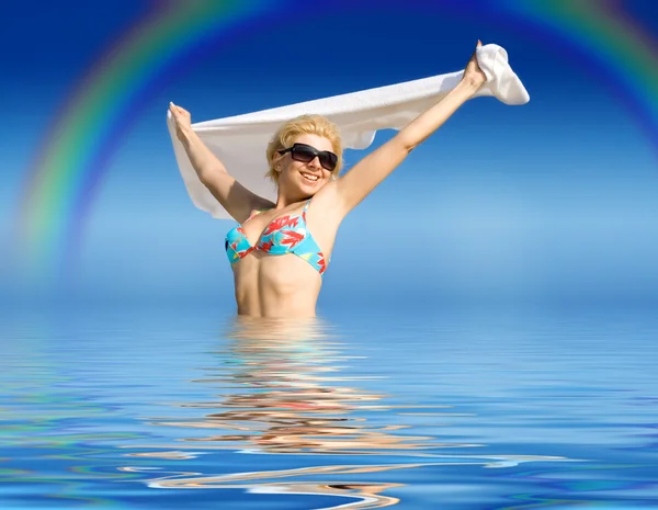 Счастливая девушка с полотенцем, стоящим в воде — стоковое фото