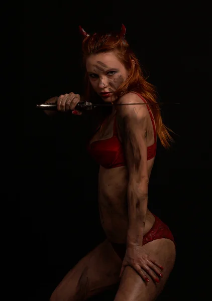 Mörk röd djävul flicka med en kniv — Stockfoto