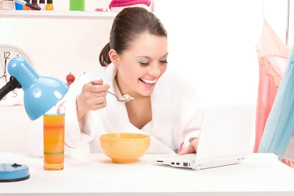Comer computador portátil mulher — Fotografia de Stock